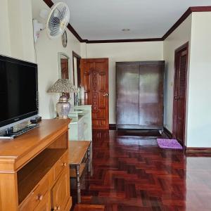 Ban Tha KupにあるWooden house and birdsong2のリビングルーム(木製ドレッサーの上にテレビ付) +3枚の写真