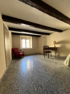 an empty living room with a red chair and a desk at Antica Dimora in Catanzaro
