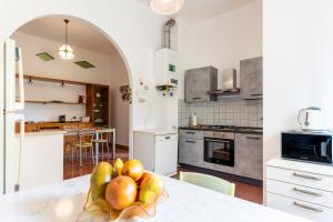 a kitchen with a table with a bowl of fruit at Marradi Apartment with Balcony in Livorno