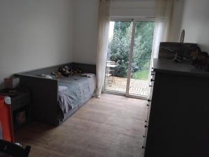 una camera da letto con un letto e una porta scorrevole in vetro di Maison Vitry Sur Seine proche Paris, métro et toutes commodités a Vitry-sur-Seine