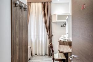 a room with a window with a table and a curtain at Spagna Boutique Suites in Rome