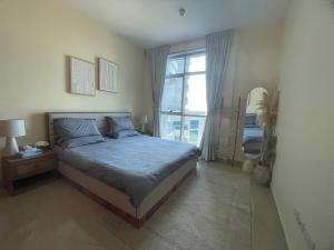 a bedroom with a bed and a large window at Beachfront gem, waves and sunset in Ajman 