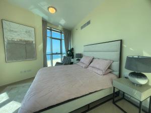 a bedroom with a large bed and a chair at Beachfront gem, waves and sunset in Ajman 