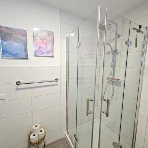 a glass shower stall in a white bathroom at Urban Suites HBN in Heilbronn