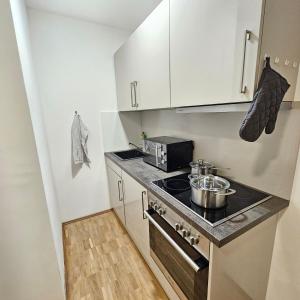 a small kitchen with a stove and a microwave at Urban Suites HBN in Heilbronn +5 photos