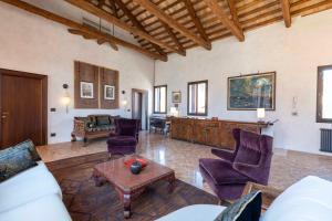 a living room with purple chairs and a table at Palazzo Remer - luxury apartments - by Bricola Apartments in Venice