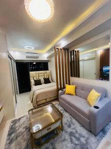 a living room with a couch and a bed at Modern Makati Condo with Balcony & Cityscape Views in Manila