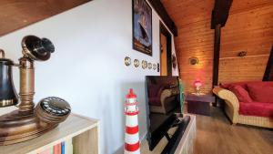 a living room with a stove and a red couch at Ferienhaus Ankerplatz Twielenfleth im Feriendorf Altes Land in Hollern-Twielenfleth