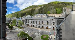 a large building with a mountain in the background at La Belle Époque Studio in Le Mont-Dore