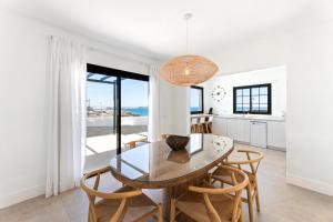 a kitchen and dining room with a table and chairs at Villas Volcan in Playa Blanca