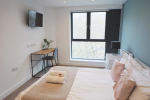 a bedroom with a bed and a desk and a window at Redcross studio flat 312 in Bristol