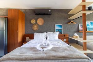 - une chambre avec un grand lit et 2 cygnes faits de serviettes dans l'établissement CONDOMINIO GAMBOA - 190 METROS DA PRAIA DO PATACHO, à Porto de Pedras 147 autres photos