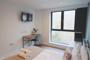 a bedroom with a bed and a window and a desk at Redcross studio flat 312 in Bristol