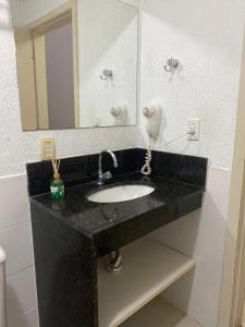 a bathroom with a sink and a mirror at Aldeia das Águas Village Park Flat A110 térreo in Barra do Piraí +13 photos