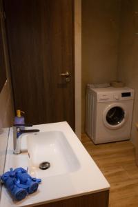 a bathroom with a sink and a washing machine at Golden sand apartment B in Hersonissos