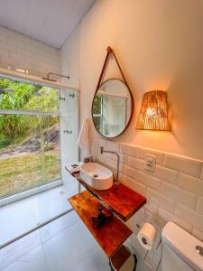 a bathroom with a sink and a mirror on the wall at Vivenda Apua Chalés in Piracaia +64 photos
