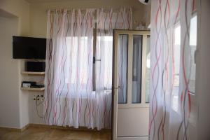 a room with a door and a window with curtains at Apartment Mythos Myrto in Pitsidia