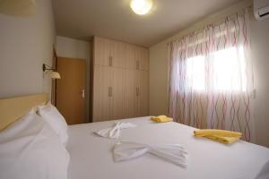 a bedroom with a white bed with bows on it at Apartment Mythos Myrto in Pitsidia +16 photos
