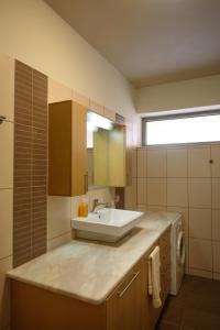 a bathroom with a sink and a mirror at Apartment Mythos Myrto in Pitsidia