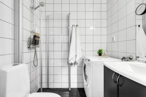 une salle de bain blanche avec une machine à laver et un lavabo dans l'établissement City Center Apartment, à Tromsø