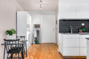 une cuisine et une salle à manger avec une table et des chaises dans l'établissement City Center Apartment, à Tromsø 8 autres photos