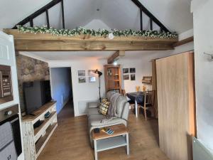 a living room with a couch and a tv at Sied Yr Ardd in Ystradgynlais