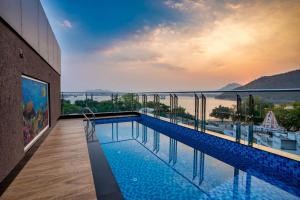 a swimming pool on a building with a view of the water at The Grand Fateh in Udaipur