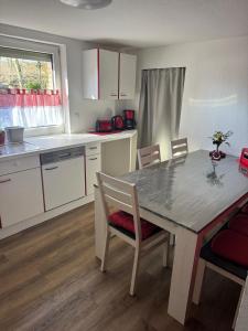 a kitchen with a table and chairs and a kitchen with white cabinets at Zur schönen Rosenblüte, Ferienhaus in Schülern