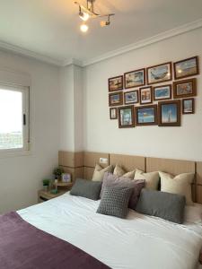 a bedroom with a bed with pictures on the wall at Apartamento 3 habitaciones en la playa de Magic World , Oropesa del Mar in Cabanes +12 photos