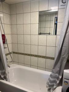 een badkamer met een ligbad en een spiegel bij Small house in Vilnius