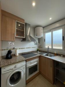 a kitchen with a washing machine and a sink at Apartamento 3 habitaciones en la playa de Magic World , Oropesa del Mar in Cabanes