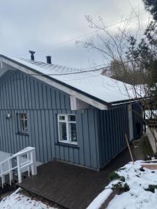 een klein blauw huis met een met sneeuw bedekt dak bij Small house in Vilnius