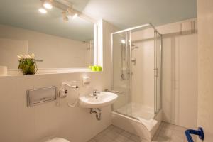 a bathroom with a shower toilet and a sink at Erzgebirgshotel Freiberger Höhe in Eppendorf +41 photos