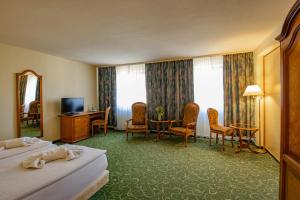 a hotel room with two beds and a table and chairs at Erzgebirgshotel Freiberger Höhe in Eppendorf
