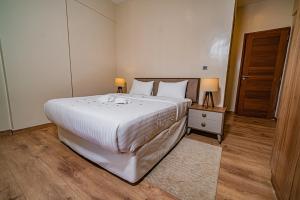 a bedroom with a large white bed and two lamps at The Lofts on Wood Avenue in Nairobi