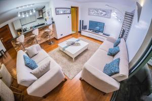 a living room with two couches and a tv at The Lofts on Wood Avenue in Nairobi