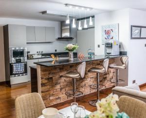 a kitchen and living room with a bar with stools at The Lofts on Wood Avenue in Nairobi +7 photos