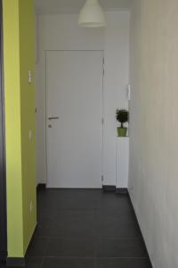 a hallway with a white door and a potted plant at Studio 24 Oostende in Ostend