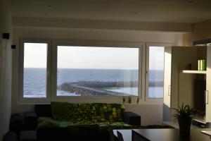 ein Wohnzimmer mit einem großen Fenster mit Meerblick in der Unterkunft Studio 24 Oostende in Ostende