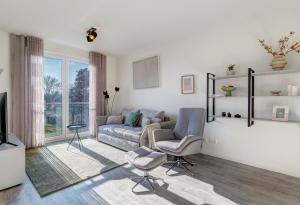 a living room with a couch and a chair at Apartment B 5 "Pine Hill Resort" in Zirchow