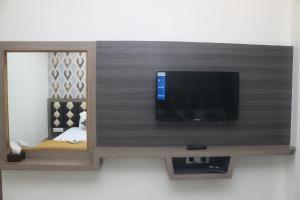 UlhāsnagarHotel Grace Lodging & Boarding的墙上的平面电视