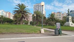 a street light in a park with palm trees and buildings at Depto Brown in Mar del Plata