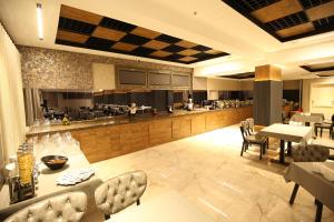un restaurante con mesas y sillas y un bar en Büpa delüxe hotel, en Kayseri