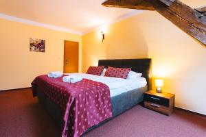 a bedroom with a large bed with a red blanket at Elzet penzion in Třeboň +29 photos
