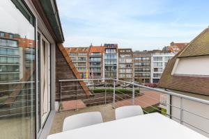 - Balcón con mesa, sillas y edificios en Villa Normandie 22 Gar, en Knokke