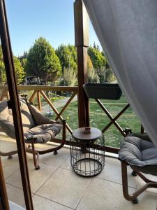 een balkon met stoelen en een tafel en uitzicht op een veld bij La Casa Verde Butik Otel in Izmir