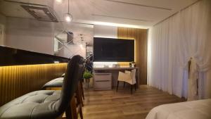 a bedroom with a desk with a computer and a television at Studio Pomerode in Pomerode