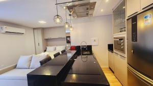 a living room with a couch and a kitchen at Studio Pomerode in Pomerode
