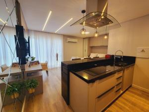 a kitchen and living room with a kitchen island in a room at Studio Pomerode in Pomerode