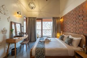 PaudThe Foresta Resort ,Mulshi的一间卧室设有一张带砖墙的大床 更多37张照片
